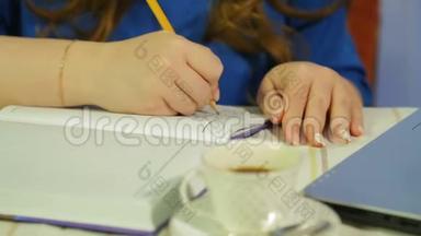 女人`手在咖啡馆的桌子上工作，她们写日记
